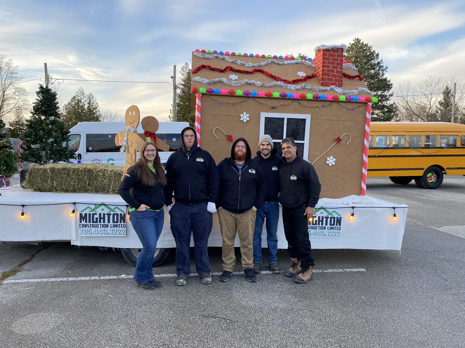 The Mighton Construction team standing in front of their gingerbread-house float before the 2023 Santa Claus Parade in Wasaga Beach