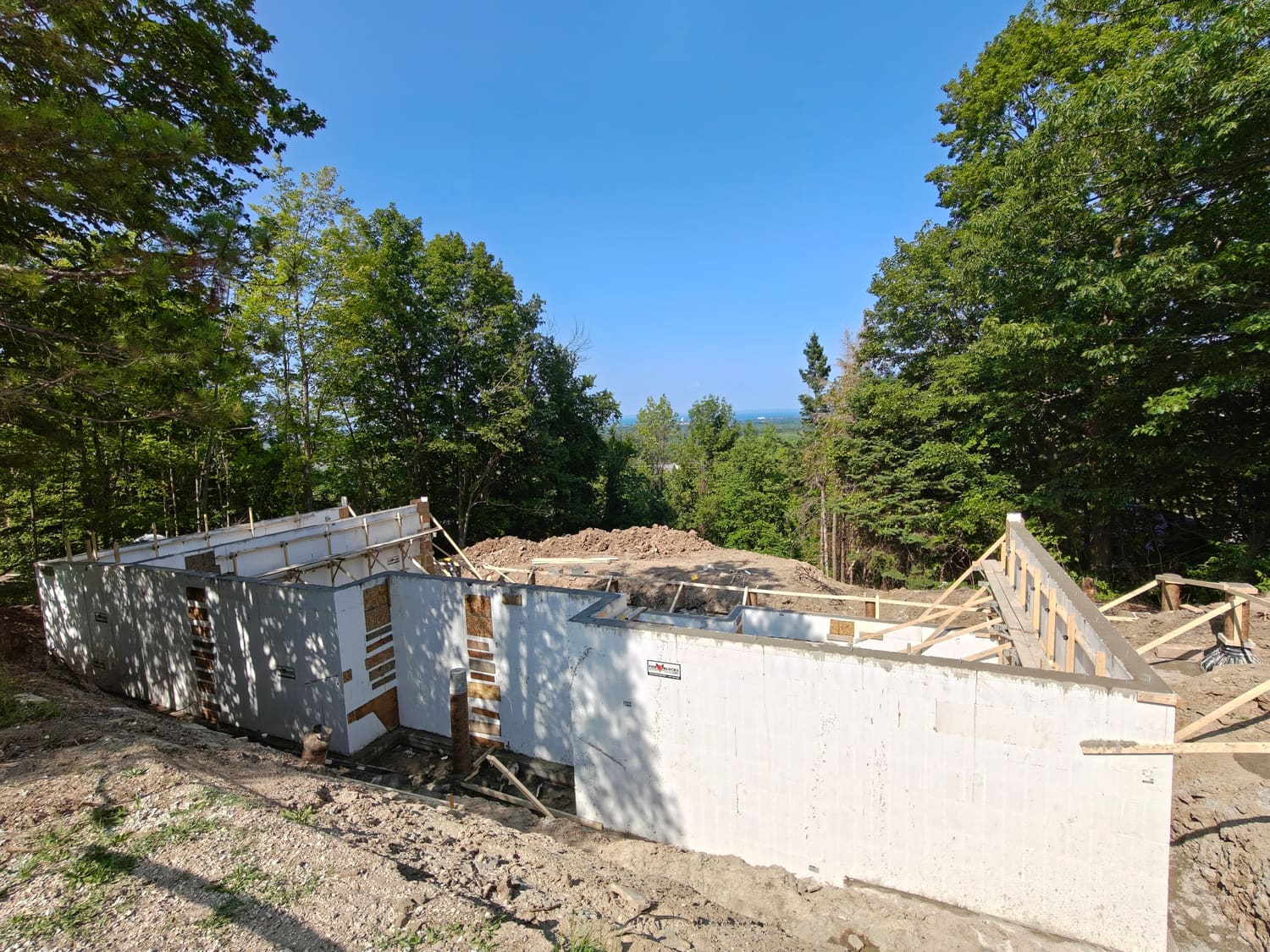 ICF house walls and garage wall forms at 105 Orchard Lane, Clearview, with water in the distance