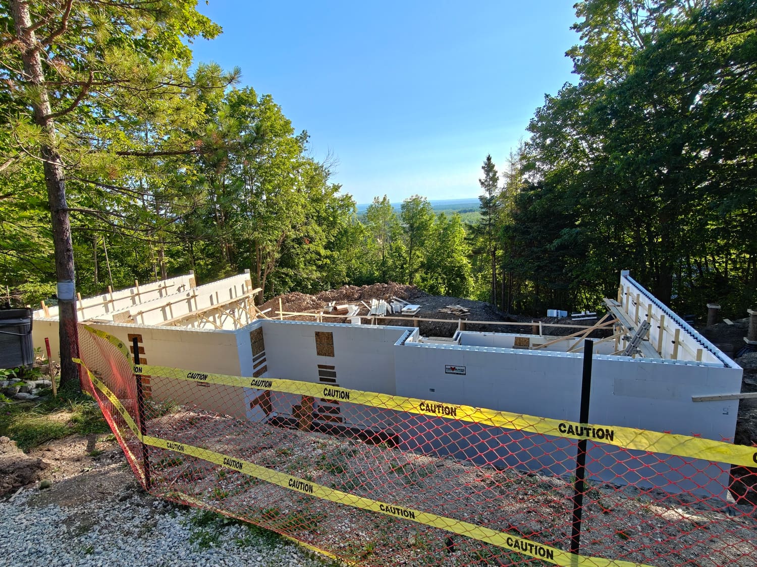 Fox Blocks ICF foundation walls rising behind safety fencing at 105 Orchard Lane in Clearview