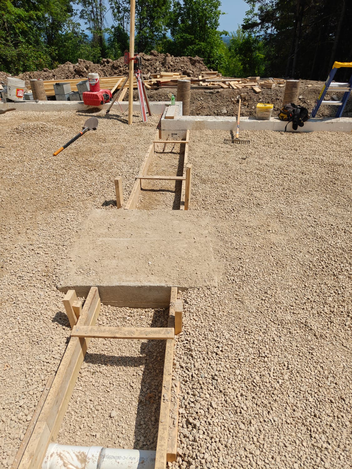Clear stone sub-base and wood forms inside the 105 Orchard Lane foundation in Clearview