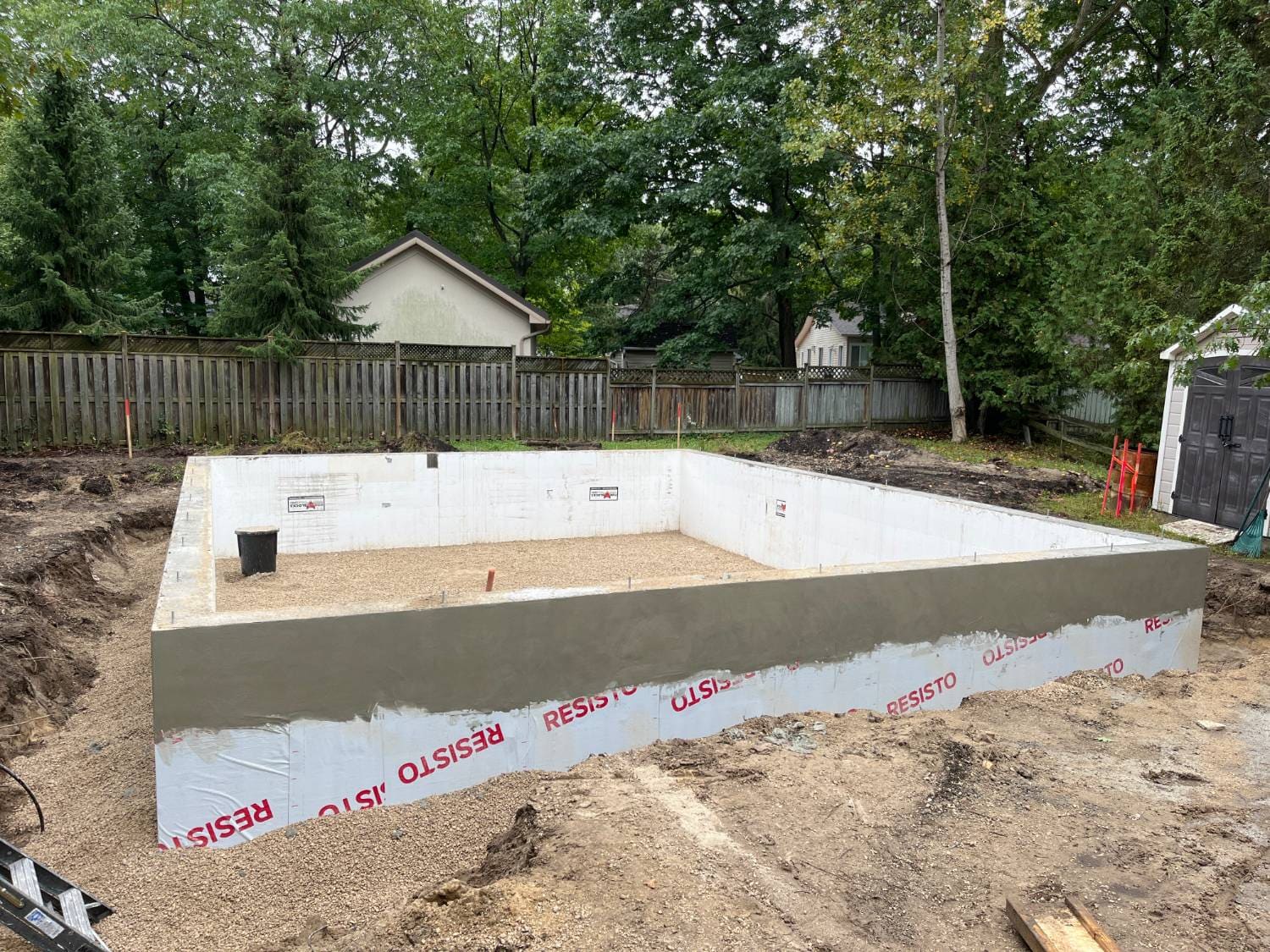 Finished ICF frost wall with exterior membrane and a stone base inside at 21 1st Lane in Wasaga Beach