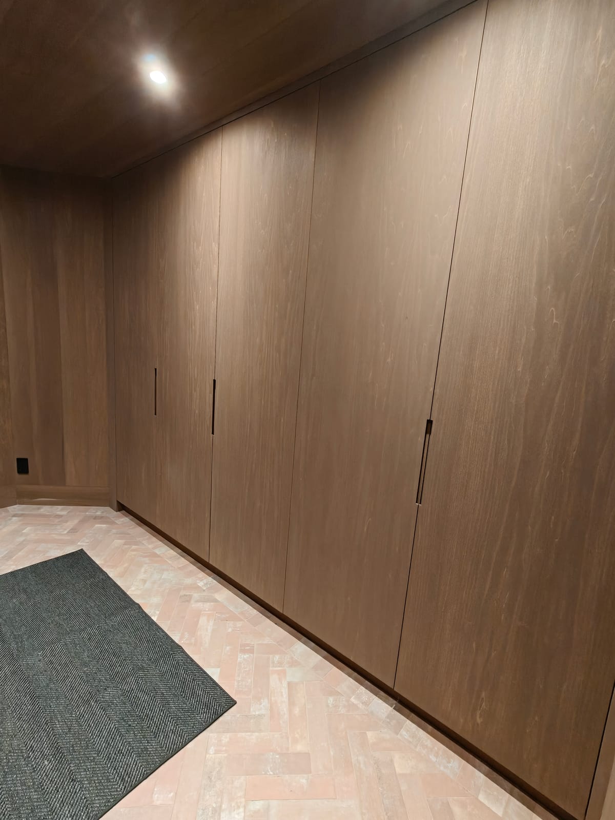 Floor-to-ceiling mudroom storage cabinets in a darker wood finish, 23 Forest Drive renovation in Collingwood