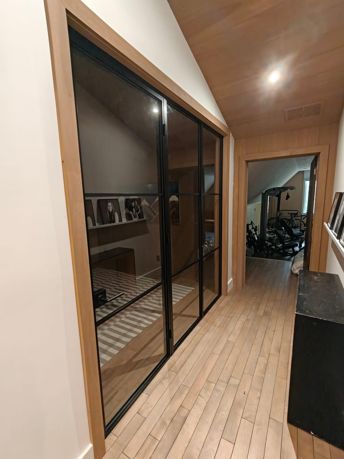 Black steel-framed glass doors opening from a hallway into an office at 23 Forest Drive, Collingwood