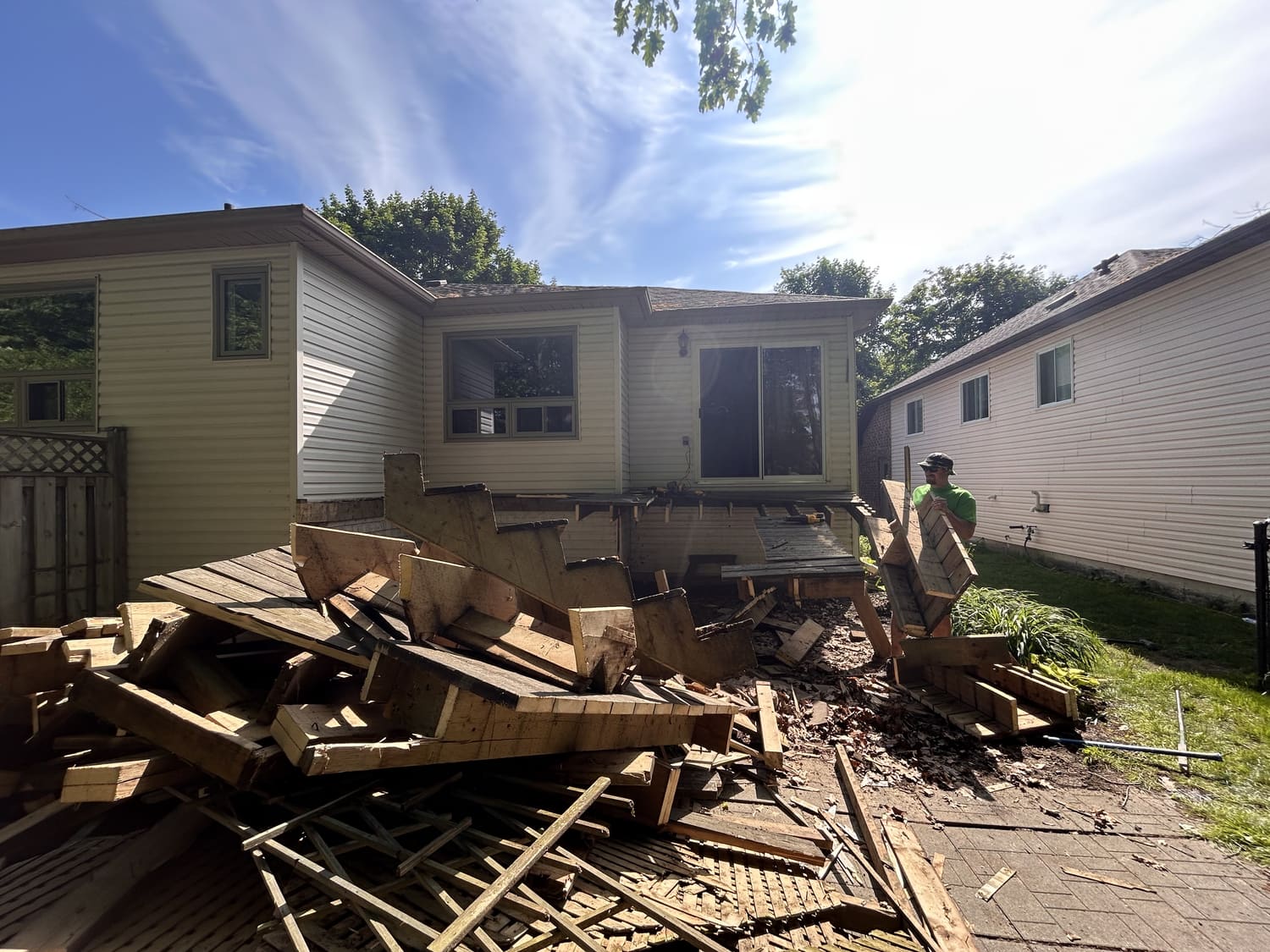 Pile of demolished old deck lumber behind the house at 46 Timberland Cres in Wasaga Beach