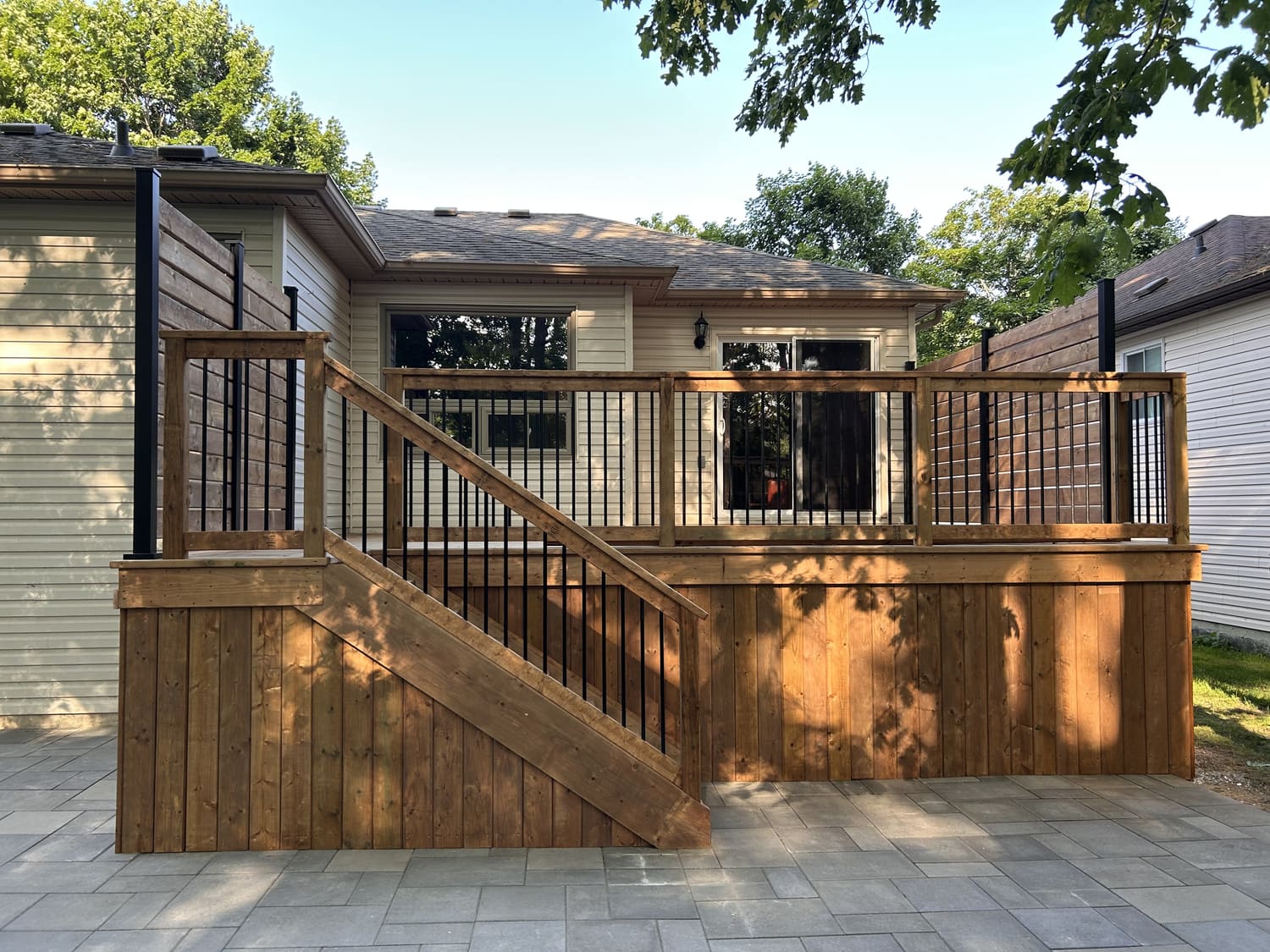Finished pressure-treated deck with aluminum picket railings, privacy walls and new paving stone patio at 46 Timberland Cres in Wasaga Beach