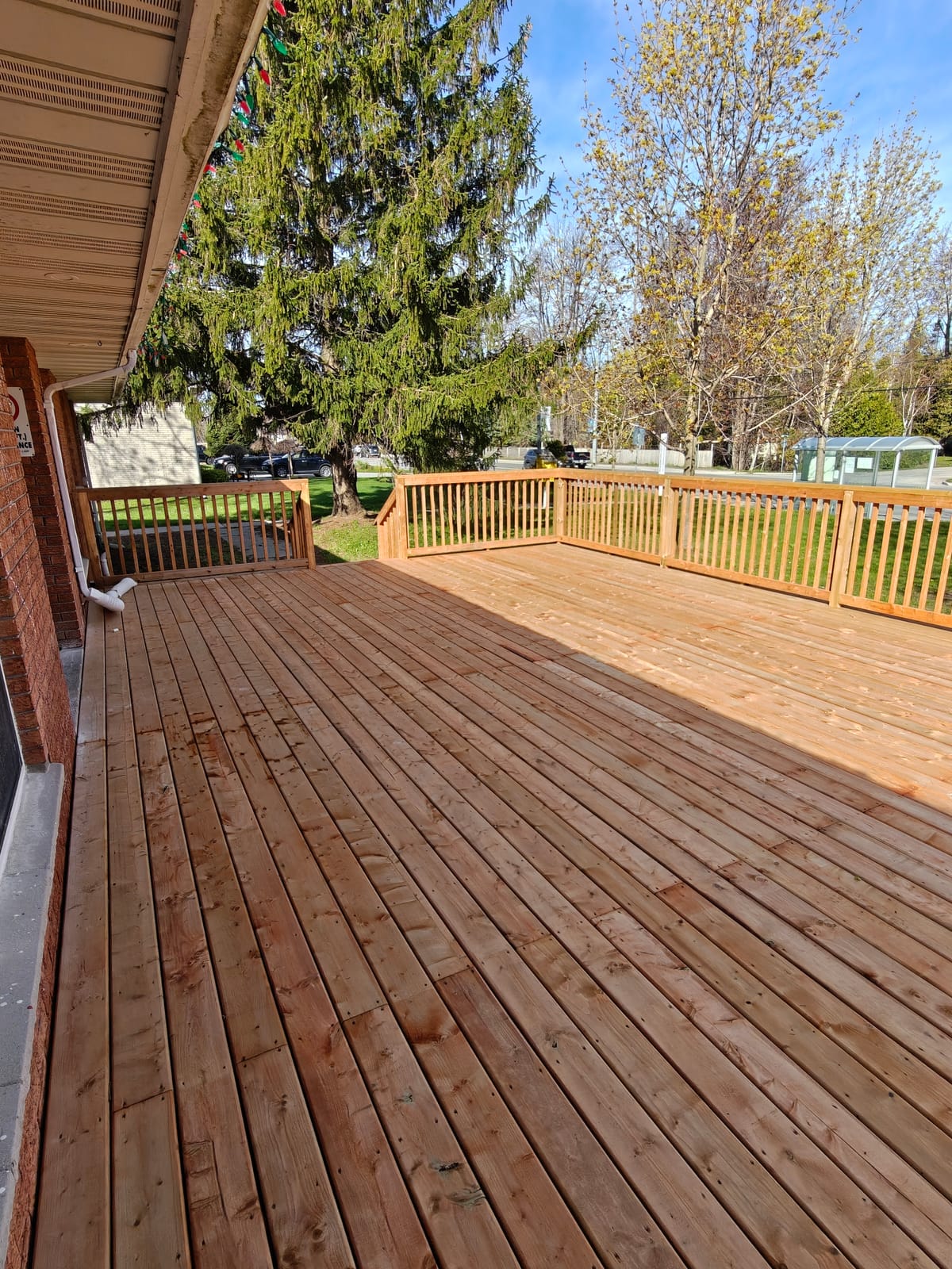 New pressure-treated deck beside the brick Youth Centre building in Wasaga Beach