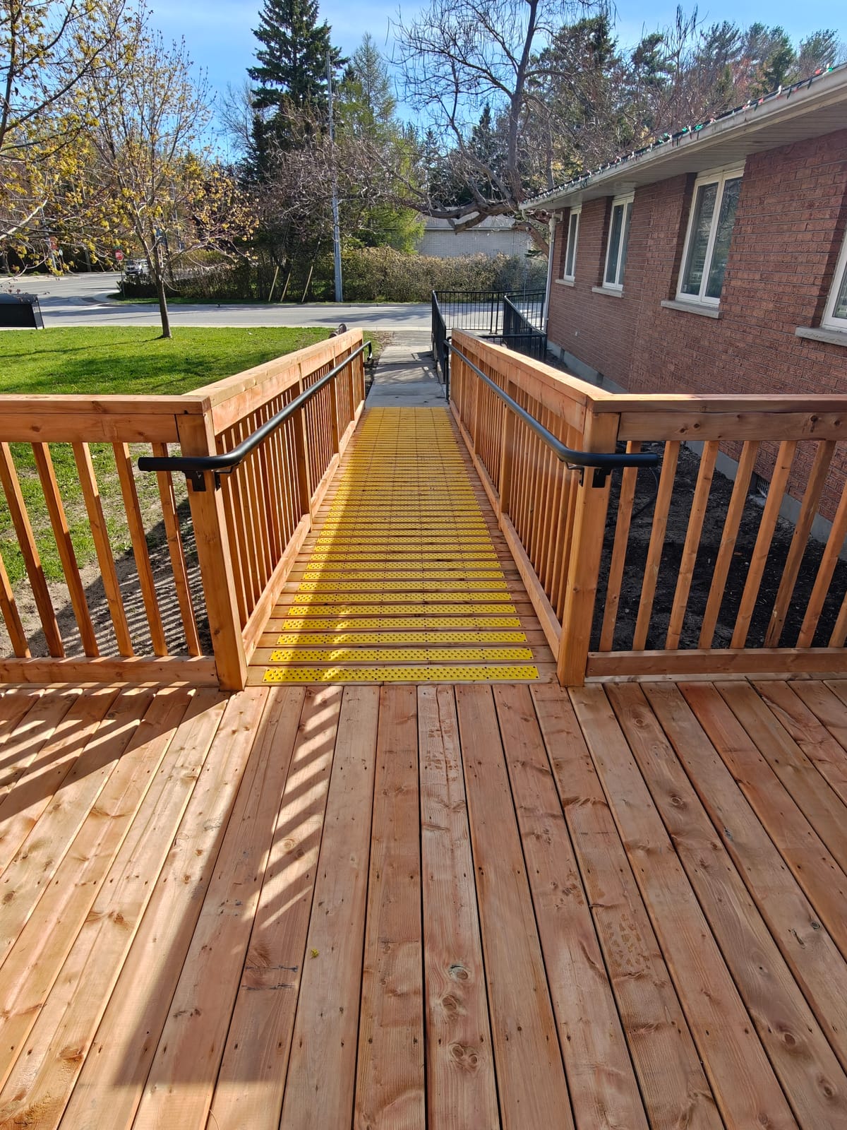 AODA-compliant accessible ramp with handrails on both sides and a slip-resistant surface at the Wasaga Beach Youth Centre deck
